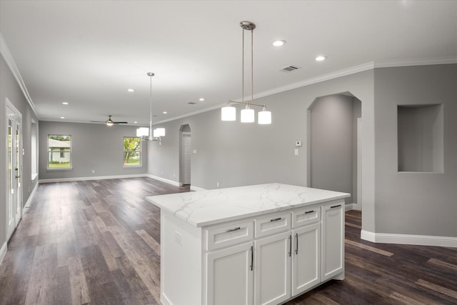 kitchen featuring white cabinetry, hanging light fixtures, dark hardwood / wood-style floors, a center island, and light stone counters