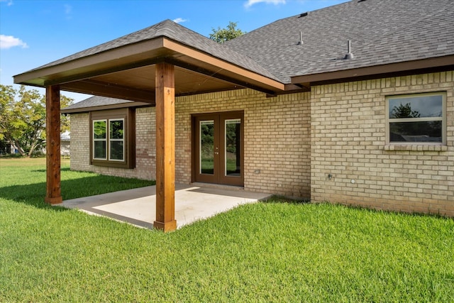 rear view of house with french doors, a yard, and a patio