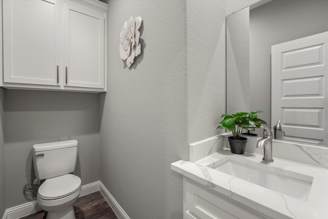 bathroom with vanity, hardwood / wood-style flooring, and toilet