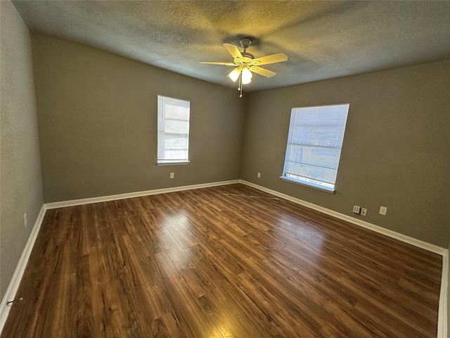 empty room featuring ceiling fan, dark hardwood / wood-style floors, and a textured ceiling