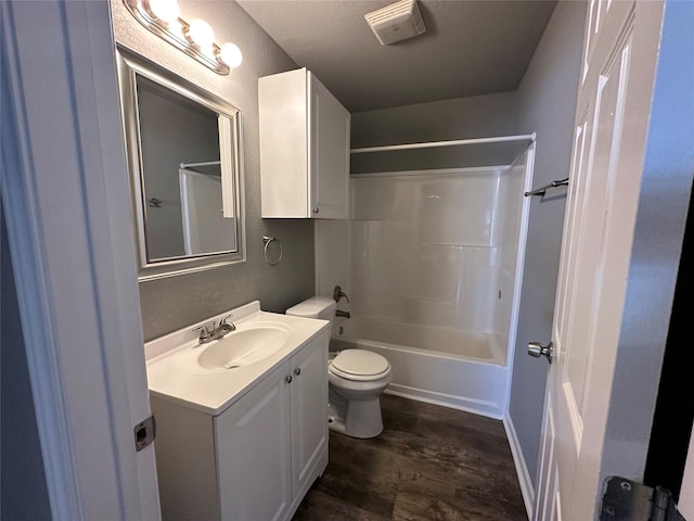 full bathroom featuring hardwood / wood-style flooring, shower / bathtub combination, vanity, and toilet