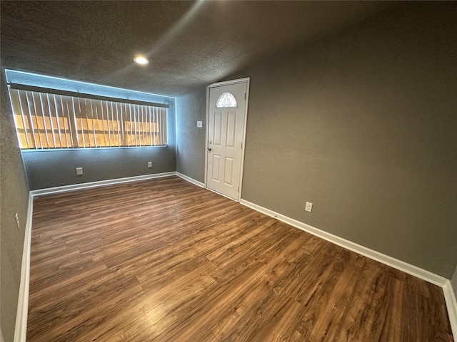 entrance foyer featuring wood-type flooring, lofted ceiling, and a textured ceiling