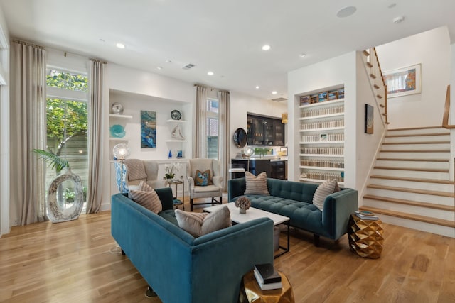 living room with built in features and light wood-type flooring