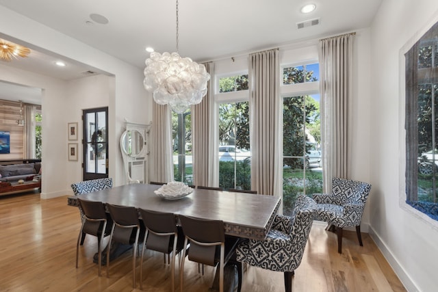 dining space featuring a notable chandelier, plenty of natural light, and light wood-type flooring