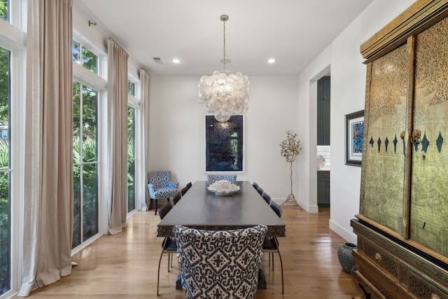 dining room featuring a notable chandelier and light wood-type flooring