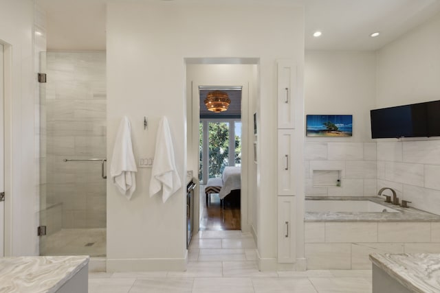 bathroom with vanity and separate shower and tub