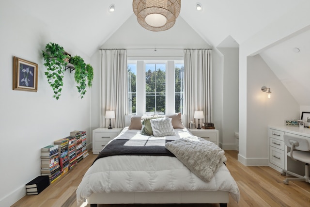 bedroom featuring built in desk, high vaulted ceiling, and light hardwood / wood-style flooring