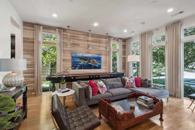 living room with wooden walls and light wood-type flooring