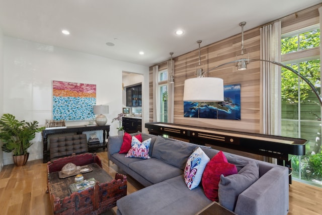 living room featuring light hardwood / wood-style floors and wood walls