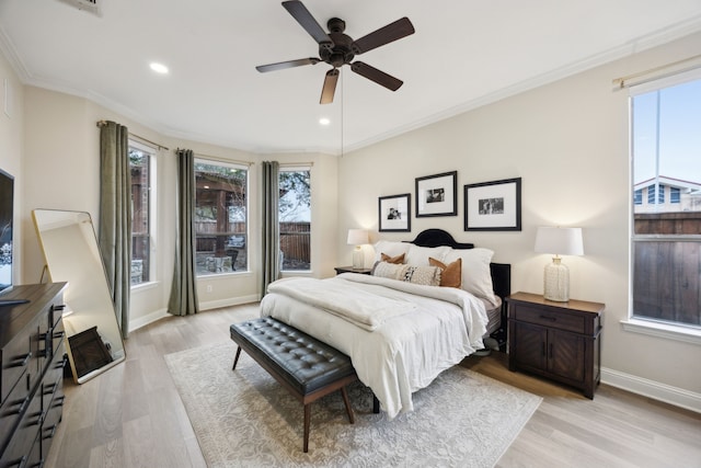 bedroom featuring multiple windows, ornamental molding, ceiling fan, and light wood-type flooring