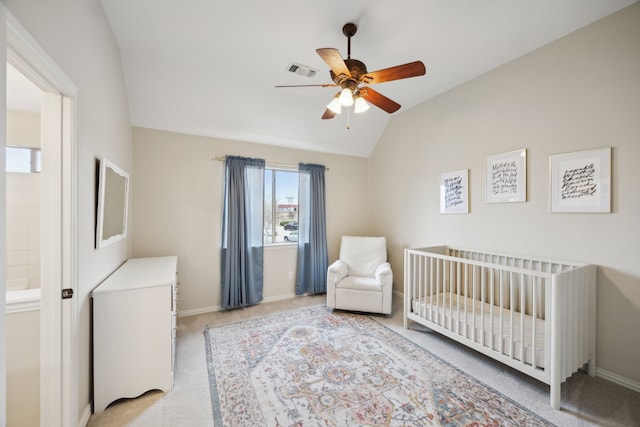 bedroom featuring ceiling fan, light colored carpet, lofted ceiling, and a crib