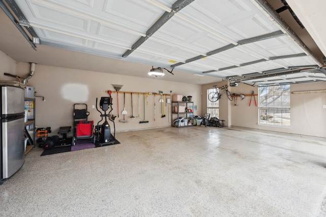 garage featuring a garage door opener and stainless steel refrigerator