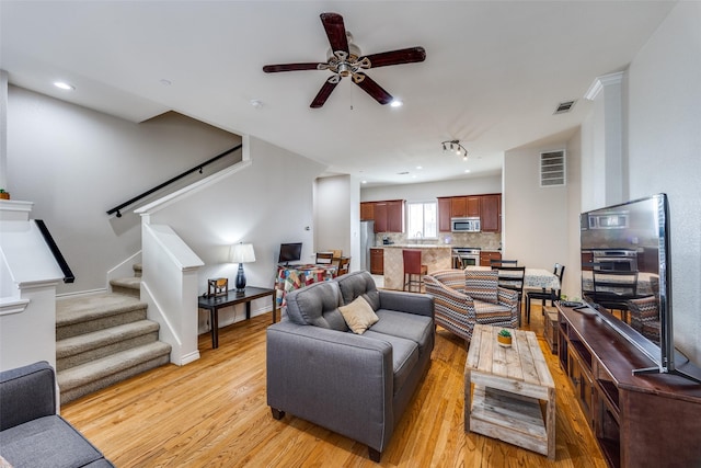 living room with ceiling fan, sink, and light hardwood / wood-style floors