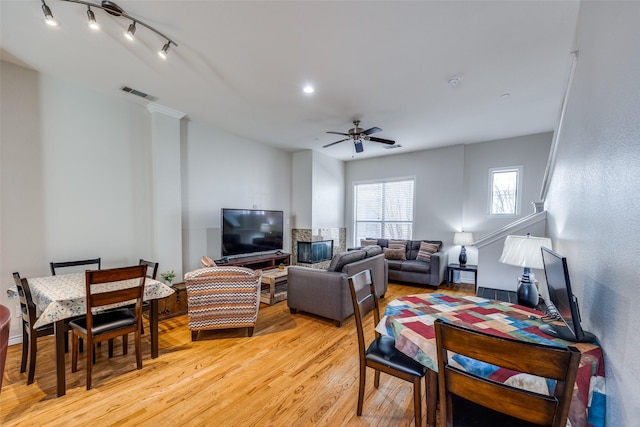 living room featuring ceiling fan, rail lighting, and light hardwood / wood-style floors