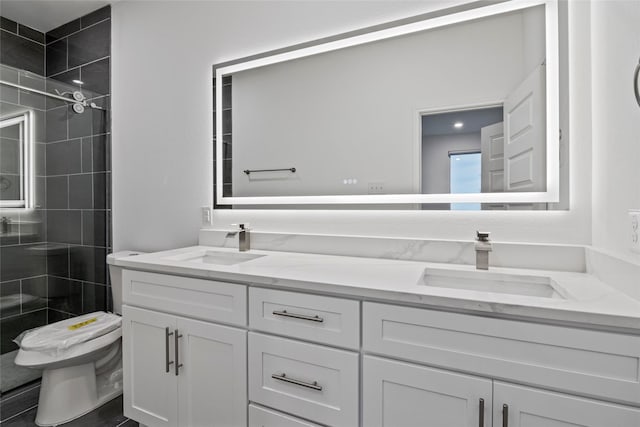 bathroom featuring vanity, tiled shower, and toilet