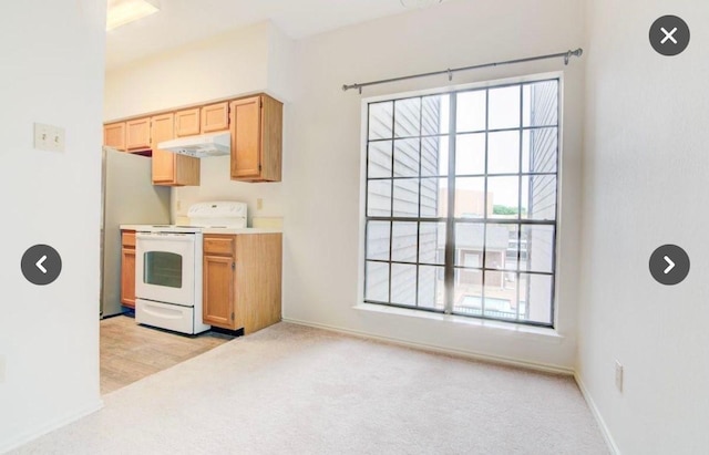 kitchen featuring white electric range oven, light colored carpet, and stainless steel refrigerator