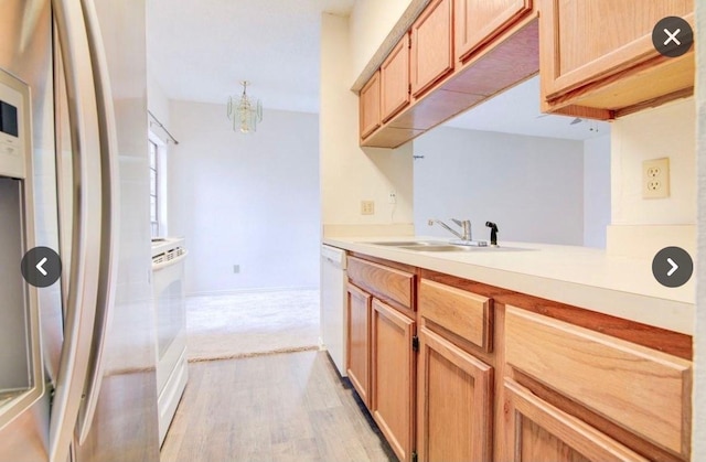 kitchen with sink, light hardwood / wood-style flooring, stainless steel refrigerator, white dishwasher, and light brown cabinets