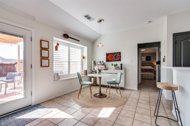 dining area featuring vaulted ceiling and light tile patterned floors