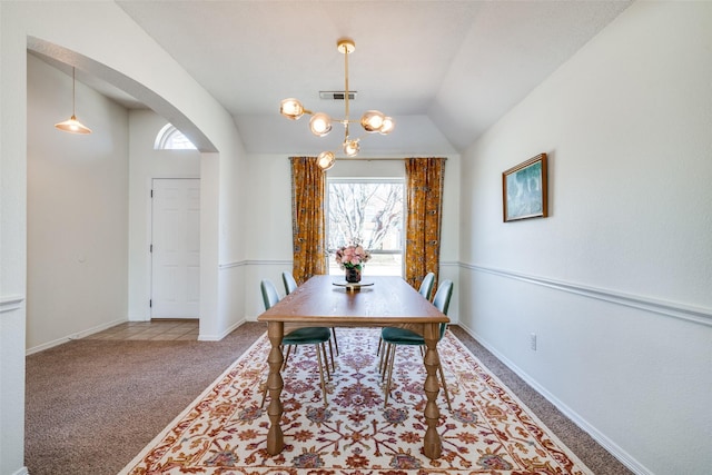 dining room with an inviting chandelier, lofted ceiling, and carpet