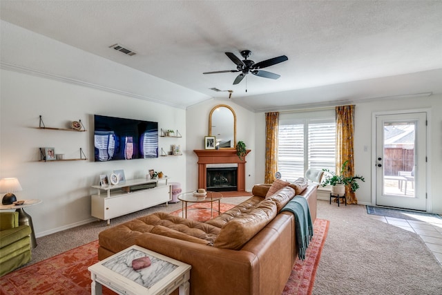 carpeted living room with ceiling fan, vaulted ceiling, and a textured ceiling