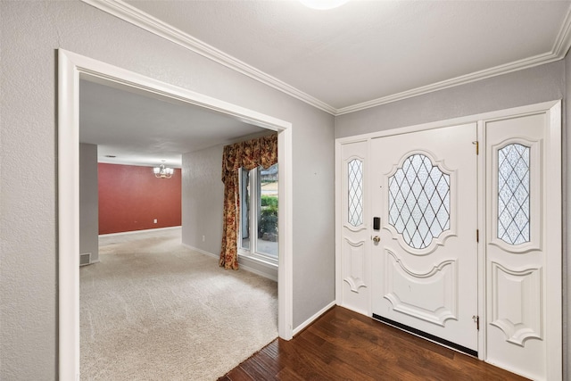 entryway with ornamental molding, dark hardwood / wood-style floors, and a notable chandelier