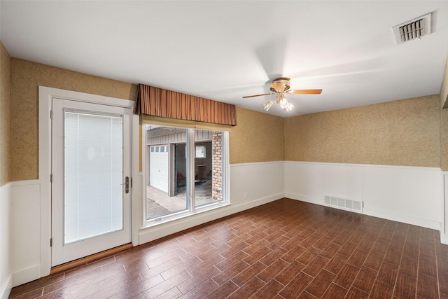 empty room with dark hardwood / wood-style floors and ceiling fan