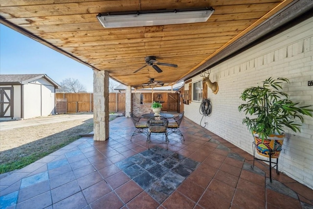 view of patio featuring ceiling fan and a shed