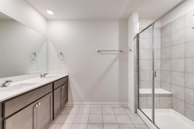 bathroom featuring double vanity, a sink, a shower stall, and tile patterned floors