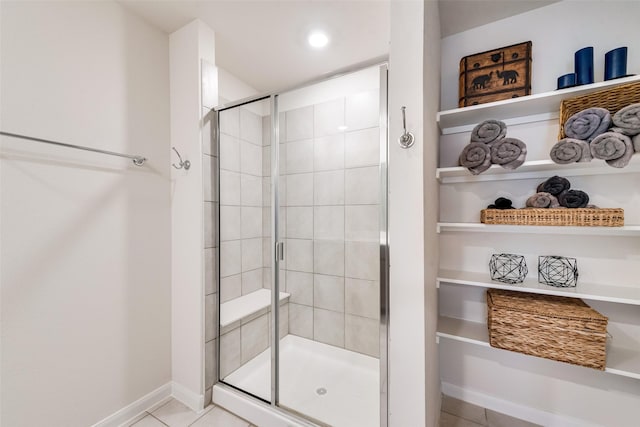 full bath featuring baseboards, a shower stall, and tile patterned floors