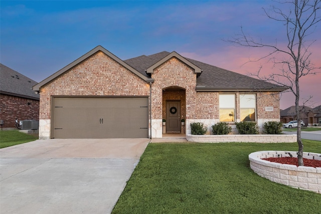 view of front of home with brick siding, roof with shingles, concrete driveway, a garage, and a front lawn