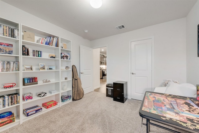 bedroom with visible vents and light carpet