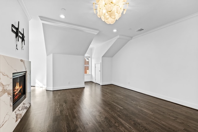 additional living space with lofted ceiling, a high end fireplace, dark hardwood / wood-style flooring, and a notable chandelier