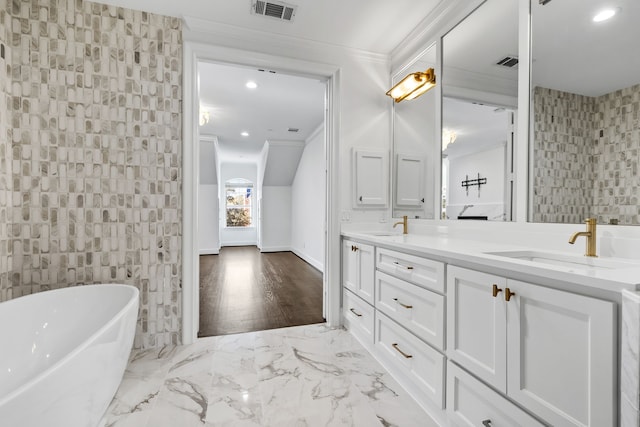 bathroom with crown molding, a washtub, vanity, and tile walls