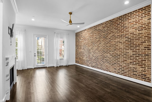 spare room with ornamental molding, brick wall, dark hardwood / wood-style floors, and ceiling fan