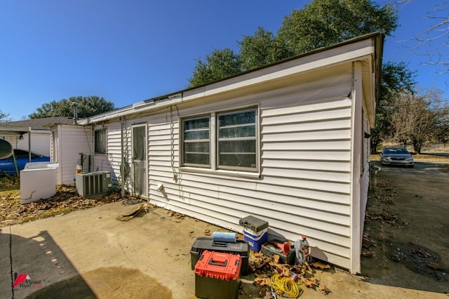 view of side of property featuring cooling unit and a patio