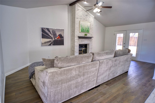 living room with dark wood-type flooring, french doors, lofted ceiling with beams, ceiling fan, and a fireplace