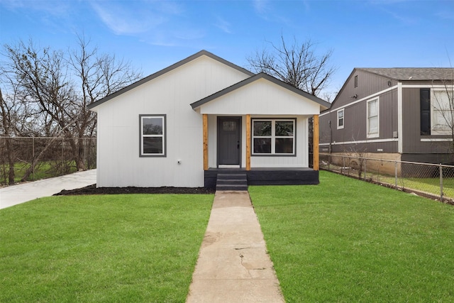 bungalow-style house with a front lawn and fence