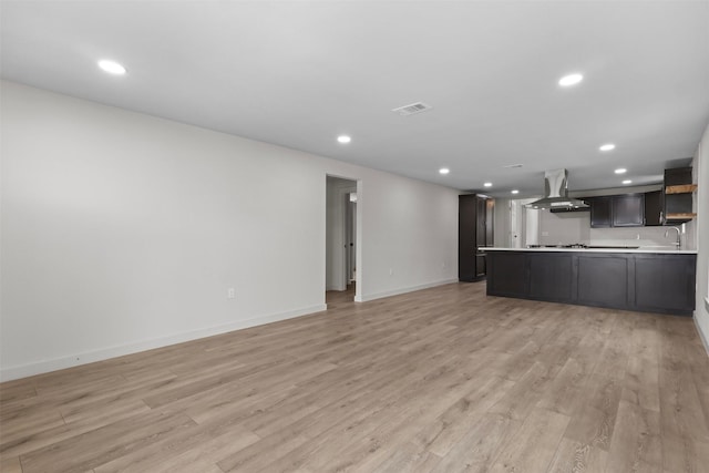 kitchen with open floor plan, light countertops, light wood-type flooring, recessed lighting, and exhaust hood