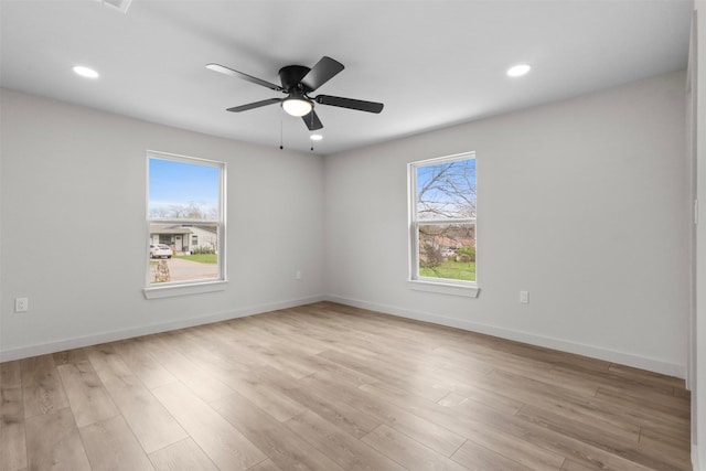 spare room with a ceiling fan, recessed lighting, baseboards, and light wood-type flooring