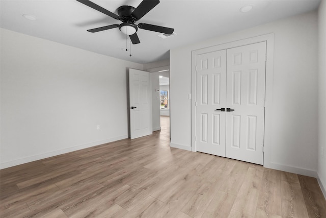 unfurnished bedroom with a closet, baseboards, ceiling fan, and light wood finished floors