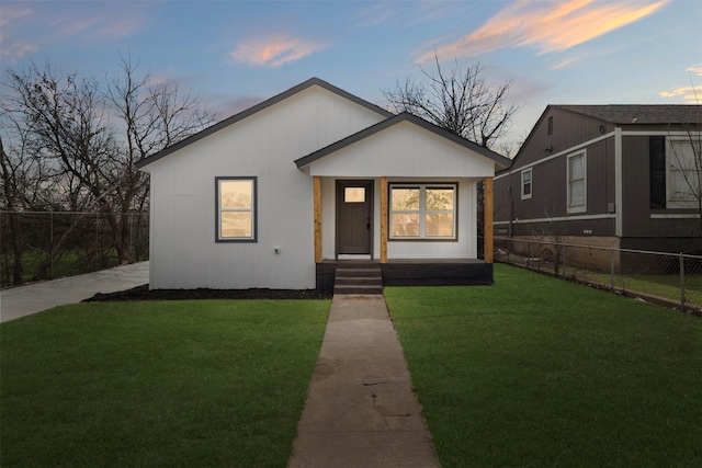 bungalow with a front yard and fence