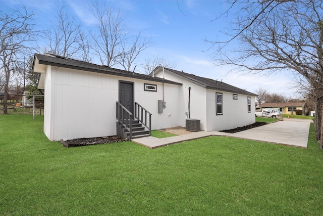 back of property with a lawn, central AC, and entry steps