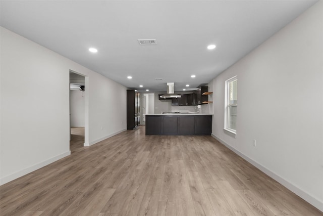 kitchen featuring visible vents, open floor plan, light countertops, light wood-style floors, and exhaust hood