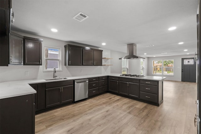 kitchen with visible vents, a sink, appliances with stainless steel finishes, a peninsula, and island range hood