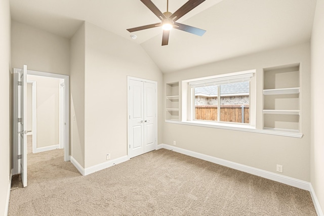 unfurnished bedroom with carpet floors, baseboards, vaulted ceiling, and a closet