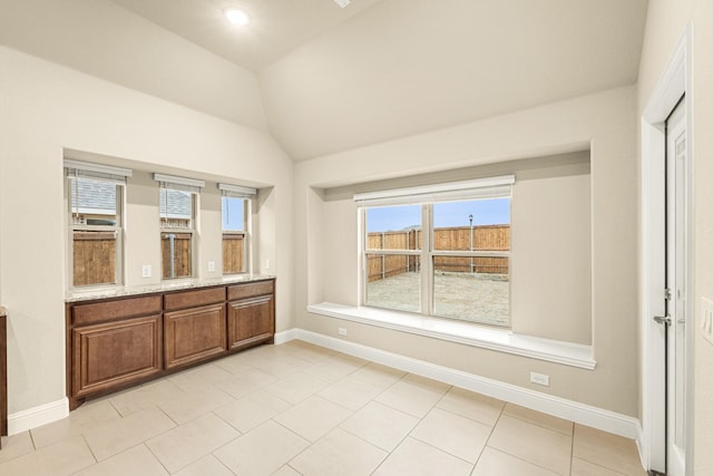 interior space featuring vaulted ceiling, vanity, and baseboards