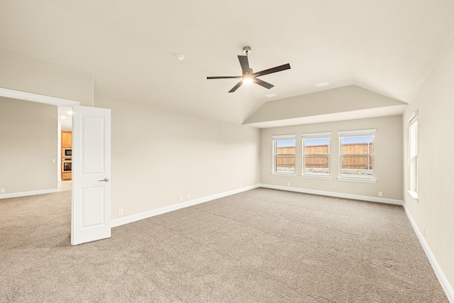 carpeted spare room with lofted ceiling, ceiling fan, and baseboards