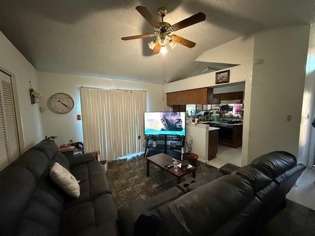 living room featuring ceiling fan, lofted ceiling, and a textured ceiling