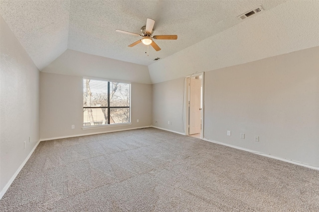 carpeted spare room with ceiling fan, lofted ceiling, and a textured ceiling