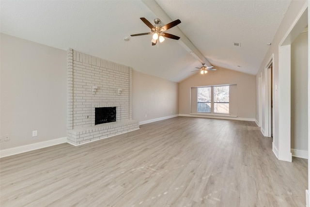 unfurnished living room featuring a fireplace, lofted ceiling with beams, light hardwood / wood-style floors, and ceiling fan